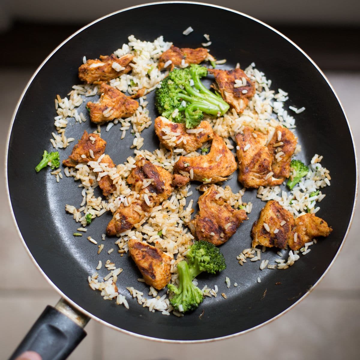 Cooked chicken and rice in a skillet, as a serving illustration